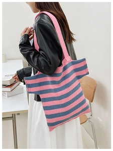 Detail of pink and blue striped knit shoulder bag in creative T-shirt shape on model