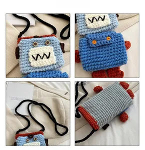 Detail shot of a handmade crochet robot bag with blue color blocks and button eye accents