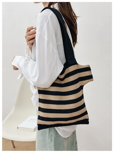 Detail of striped knitted tote bag in black and khaki featuring soft woven texture