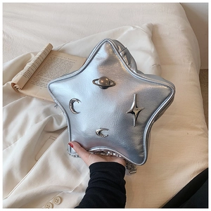Detail of silver star-shaped crossbody bag with metallic Saturn and moon charms