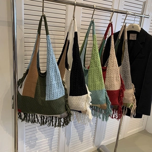 Multi-color patchwork knitted tote bags with tassels and cable knit patterns on display