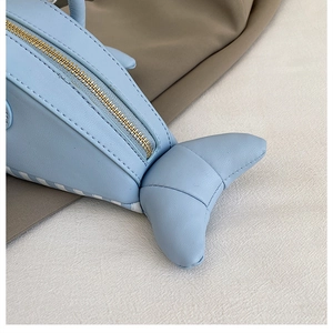 Detail of light blue whale-shaped mini bag made of textured PU leather with metal zipper