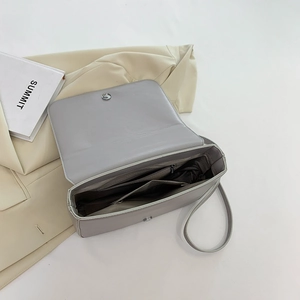 Sac brodé gris avec plusieurs compartiments intérieurs et une poche zippée