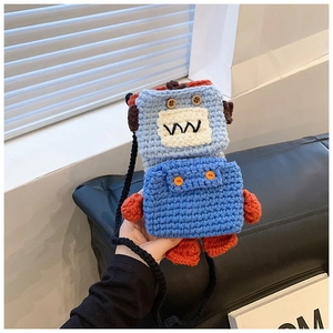 Close-up of handmade blue knit robot bag with wooden button eyes and red accents
