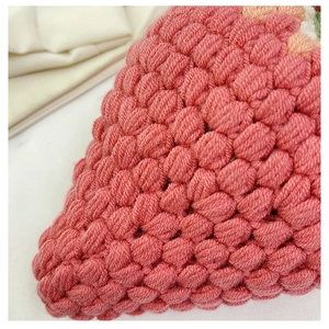 Close-up of pink handmade crochet bag showing detailed textured popcorn stitch pattern
