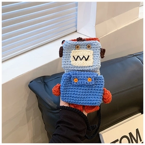 Detailed view of handmade blue crochet monster phone bag with orange limbs and button eyes