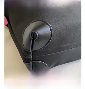 Detail of high-density black canvas bag with reinforced leather corners and pink pattern
