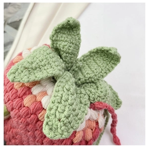 Detail of pink strawberry crochet bag featuring intricate handmade knitting texture