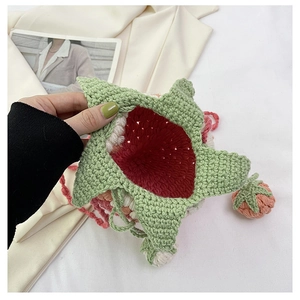 Detail of handmade crochet strawberry bag showing inner red lining and woven texture
