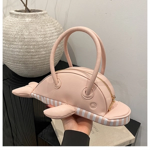 Detail of pink dolphin shaped PU leather handbag with 3D fins and metal zipper closure