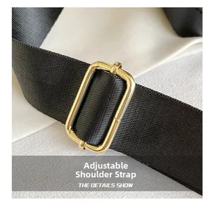 Detail of adjustable black nylon strap with polished gold-tone metal hardware buckle