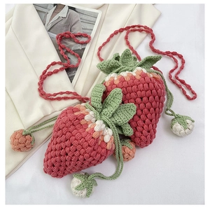 Detailed view of handmade strawberry crochet crossbody bag with textured knit stitch