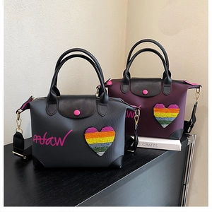 Detail of grey and purple nylon tote bags with leather handles and heart sequin patches