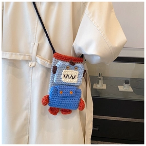Detail of handmade crochet robot crossbody bag showing knit textures and button eyes
