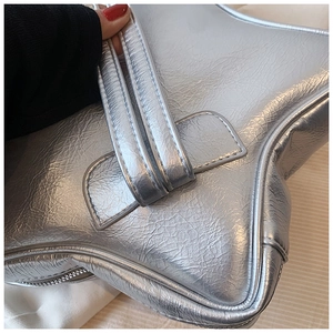Macro shot of silver star-shaped handbag featuring textured faux leather and zipper