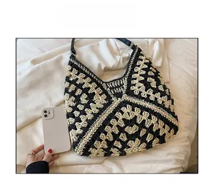Macro detail of hand-woven geometric pattern on tote bag with leather strap and smartphone