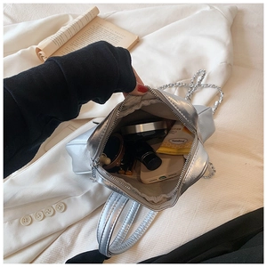 Silver metallic chain bag interior showing storage for phone, lipstick, and cosmetics