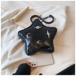 Detail of star-shaped black faux leather crossbody bag with silver celestial metal charms