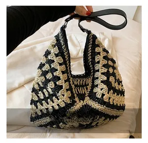 Detail showing the geometric woven pattern and black leather strap of the knit tote bag