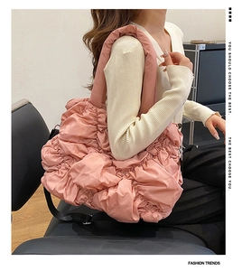 Détail du sac cabas matelassé rose avec texture froncée et bandoulière noire réglable