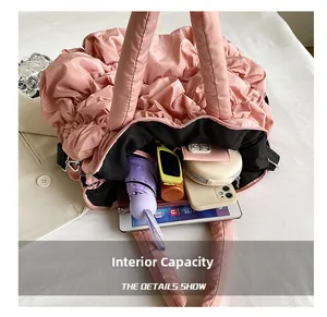 Intérieur du sac cabas rose en nylon matelassé montrant l'espace pour tablette et parapluie