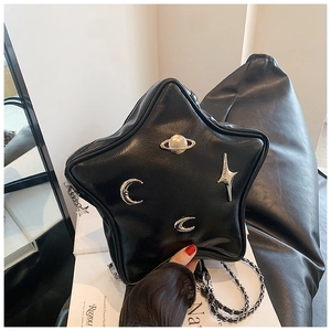 Detail of star-shaped crossbody bag featuring metallic planetary and moon charms