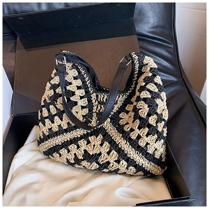 Close-up of geometric crochet pattern on woven bag with black leather shoulder strap