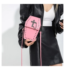Détail du sac bandoulière rose en forme de cercueil avec croix et clous noirs