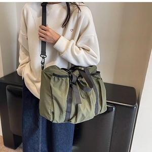 Detail of army green nylon tote bag showing oversized capacity and stylish ruched texture