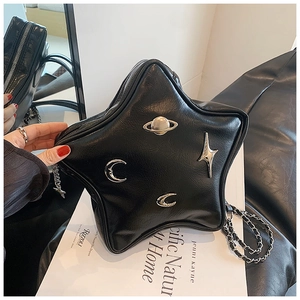 Detail of black star-shaped crossbody bag with silver celestial charms and chain strap