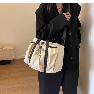 Detail of drawstring textured nylon bag showing black straps and large storage capacity