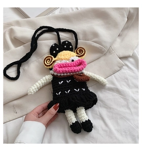 Detail of handmade crochet crossbody bag with a cartoon character design and pearl necklace