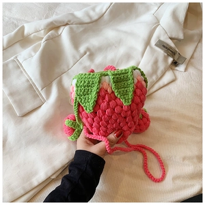 Handmade crochet strawberry crossbody bag in soft pink with green leaf detailing