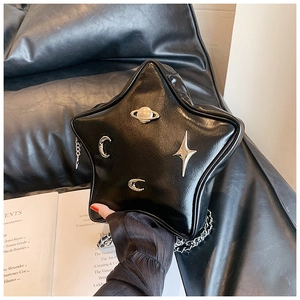 Detail of black star-shaped PU leather bag with silver moon and star metallic ornaments