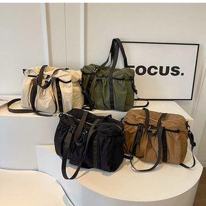 Detailed shot of large capacity functional nylon duffel bags in four earth-tone colors