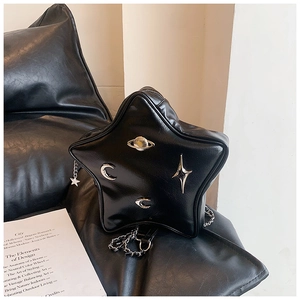 Detail of black star-shaped crossbody bag with silver celestial charms and chain strap