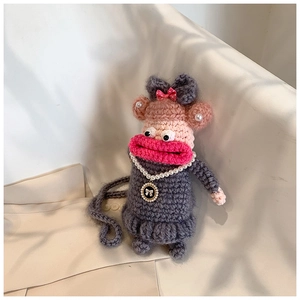 Détail d'un sac au crochet fait main avec de grandes lèvres roses et un collier de perles