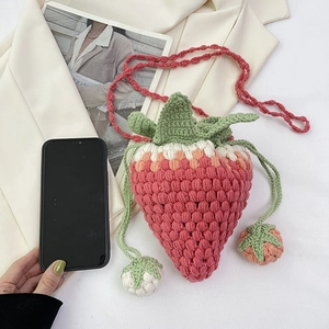 Handmade crochet strawberry crossbody bag in pink with green leaves and drawstring closure