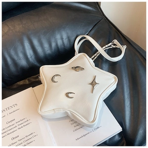 Detail shot of white star-shaped leather crossbody bag with celestial silver metal charms