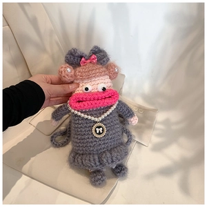 Détail d'un sac au crochet fait main avec de grosses lèvres roses et collier de perles