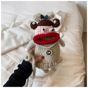 Détail du sac bandoulière fait main au crochet avec une grande bouche et collier de perles