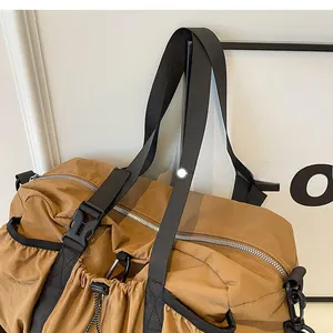 Detail of the tactical buckle and reinforced nylon handles on the khaki functional bag