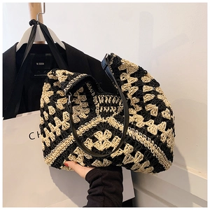 Close-up of contrast woven tote bag showing detailed crochet flowers and leather handles