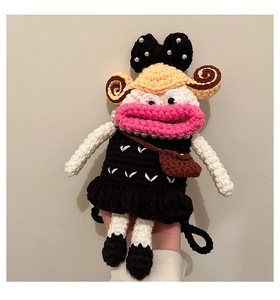 Detail of handmade crochet doll bag with black dress, pearl accents and bow decoration