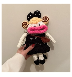 Detail of a handmade crochet doll bag with large pink lips and pearl accessories