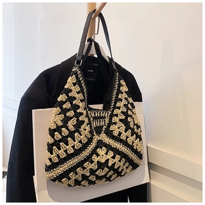 Detail of hand-woven crochet tote featuring black and cream granny square pattern texture