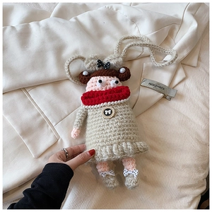 Détail d'un sac poupée au crochet fait main avec col en perles rouges et nœud