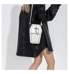 Détail d'un sac cercueil blanc avec chaînes à croix gothiques et rivets métalliques