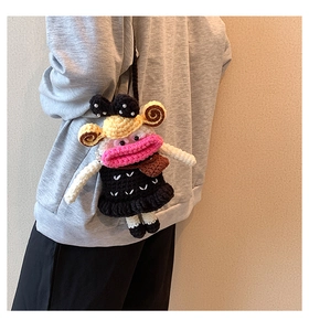 Detail of handmade crochet crossbody bag featuring pink lips and black bow accents