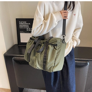 Army green nylon tote bag detail showing high-capacity design and functional shoulder strap